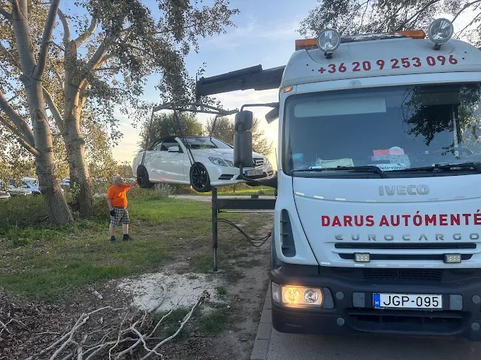 Darus autómentő emel egy Mercedes kabriót naplementében